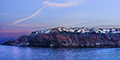 Oia sunrise with Garbinoi Myloi windmills and Ammoudi Bay to left and blue domed cathedrals to right
